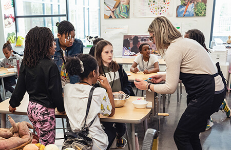 teacher in classroom with various food items