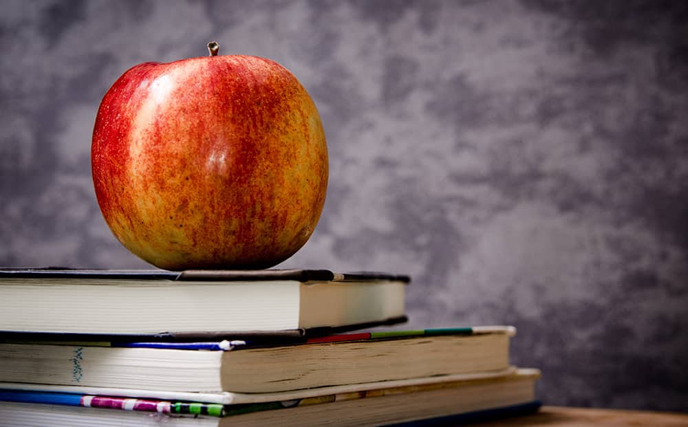 an apple sitting on books